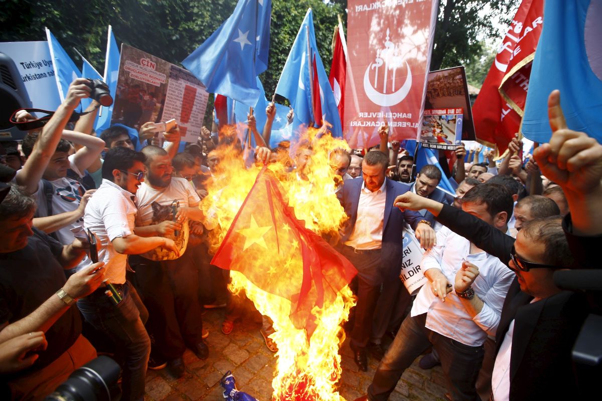 Demonstrators set fire to a Chinese flag during a protest against China near the Chinese Consulate in Istanbul