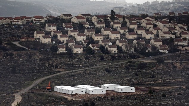 New prefabricated homes are seen under construction in the West Bank between the Israeli outpost of Amona and the settlement of Ofra (background), north of Ramallah, on January 31, 2017. (AFP/Thomas Coex)