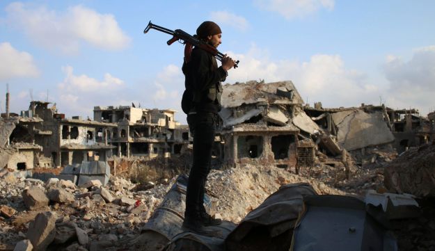 A rebel fighter standing amid the rubble of destroyed buildings in the rebel-held area of Daraa, in southern Syria, March 14, 2017.