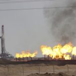 Flames emerge from a pipeline at Rumaila oilfield in Basra