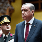 Recep-Tayyip-Erdogan-with-member-of-the-Turkish-Army-behind-him-image-via-Wikipedia-300×215